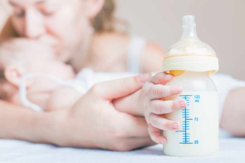 Baby Holding A Baby Bottle With Breast Milk